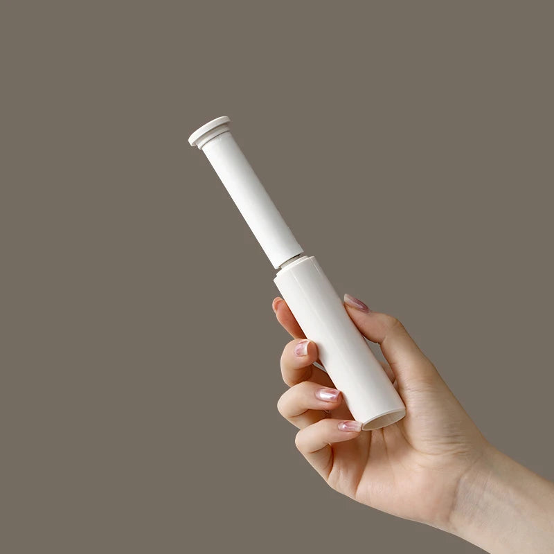 Mini rouleau anti-poils format stylo tenu en main montrant taille compacte